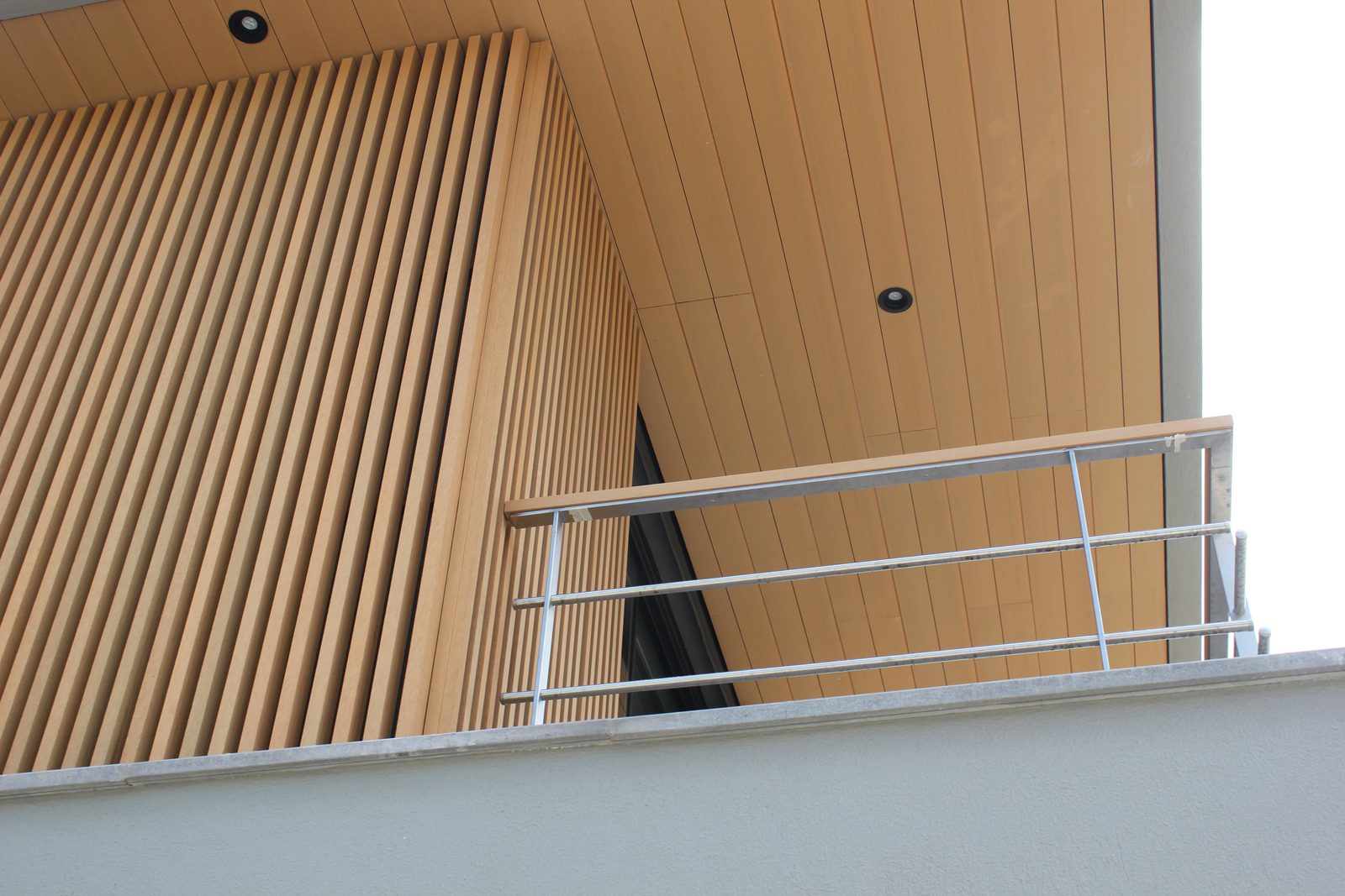 Composite wall cladding on a balcony soffit with lighting detail